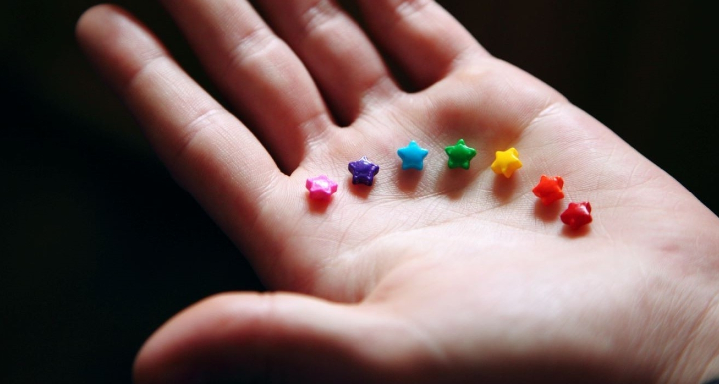 Brightly colored star-shaped sprinkles in a child's hand