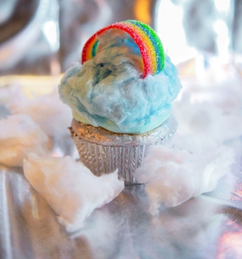 A colorful cupcake with cotton candy cloud and candy rainbow