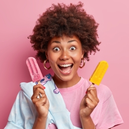 a woman holding popsicles